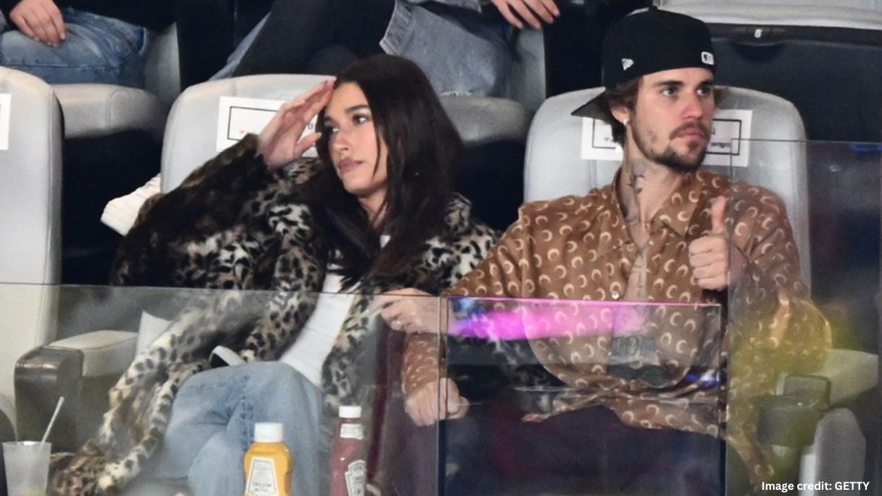 Justin Bieber and Hailey Bieber sitting in stands during Super Bowl 2024 halftime performance